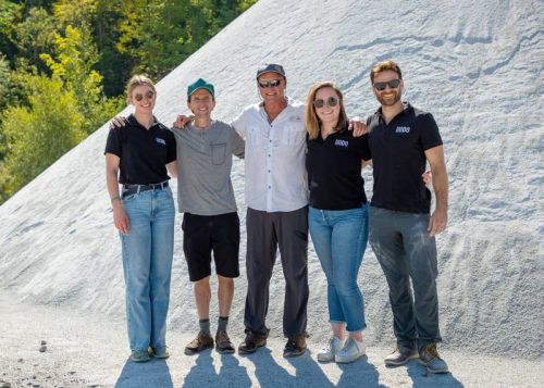 Bob Vasily (centre) president of Canadian Wollastonite with the UNDO crew in front of crushed wollastonite at the mine located near Seeleys Bay.